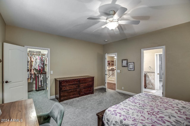 bedroom featuring connected bathroom, a closet, light carpet, a spacious closet, and ceiling fan