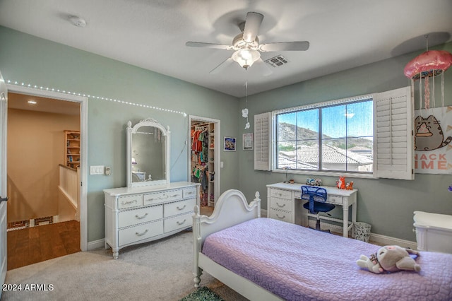 carpeted bedroom featuring a spacious closet, a closet, and ceiling fan