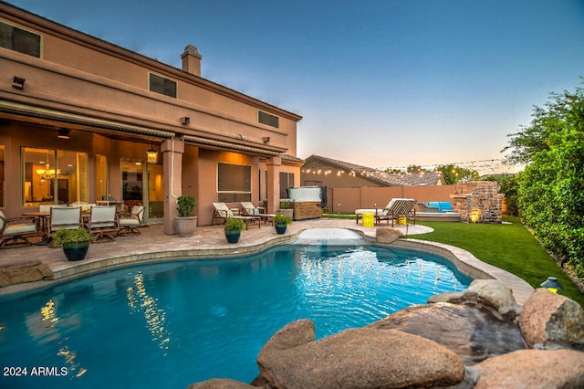 pool at dusk with a patio area