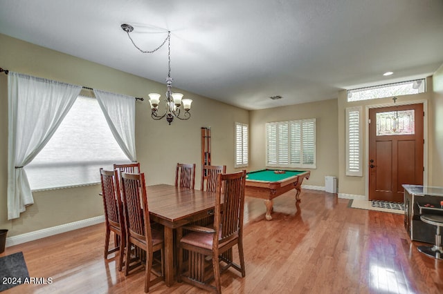 dining area featuring light hardwood / wood-style floors, an inviting chandelier, pool table, and radiator heating unit