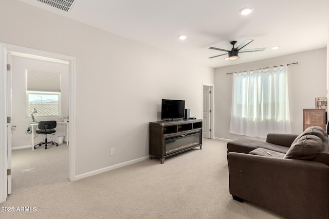 living room featuring a wealth of natural light, light carpet, baseboards, and recessed lighting