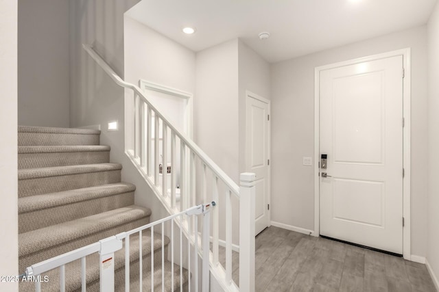 entrance foyer with stairway, recessed lighting, wood finished floors, and baseboards