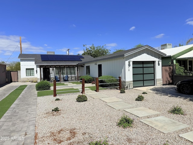 218 N Palm St, Gilbert, AZ 85234 - view of front of house with solar panels, stone siding, an attached garage, a shingled roof, and board and batten siding