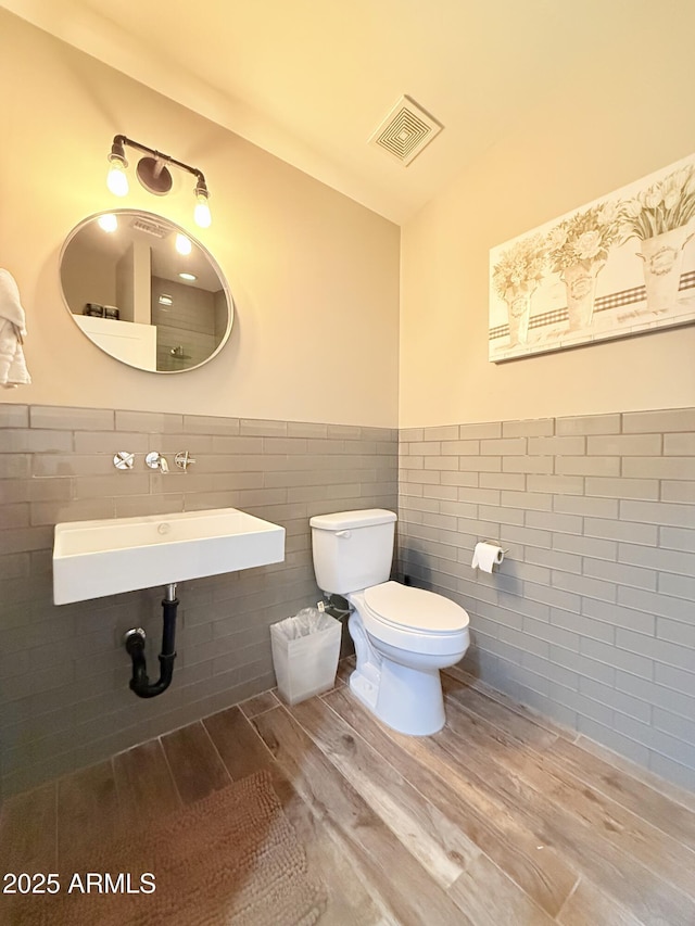 218 N Palm St, Gilbert, AZ 85234 - half bathroom with tile walls, a sink, wood finished floors, toilet, and a wainscoted wall