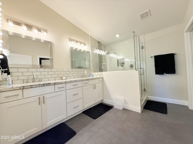 218 N Palm St, Gilbert, AZ 85234 - bathroom with double vanity, tasteful backsplash, a shower stall, tile patterned flooring, and baseboards
