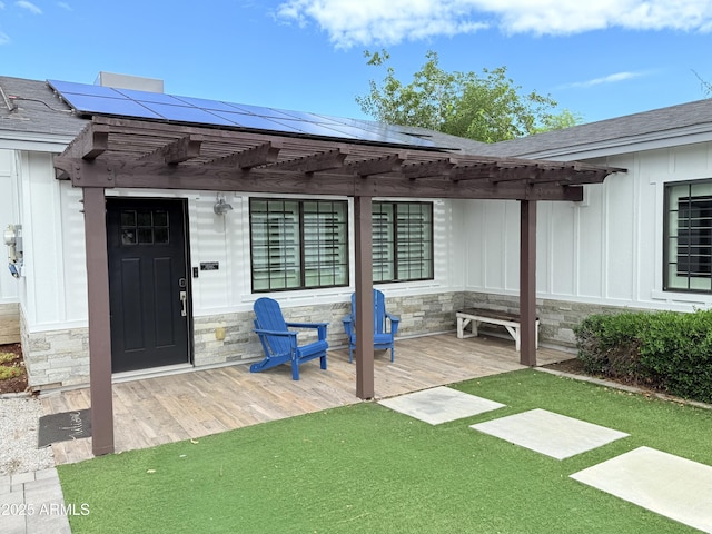 218 N Palm St, Gilbert, AZ 85234 - entrance to property featuring stone siding, a pergola, board and batten siding, a wooden deck, and roof mounted solar panels