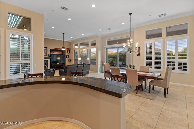 kitchen with crown molding, decorative light fixtures, and light tile patterned flooring