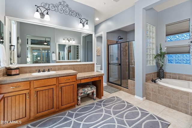 bathroom featuring tile patterned floors, shower with separate bathtub, vanity, and a wealth of natural light