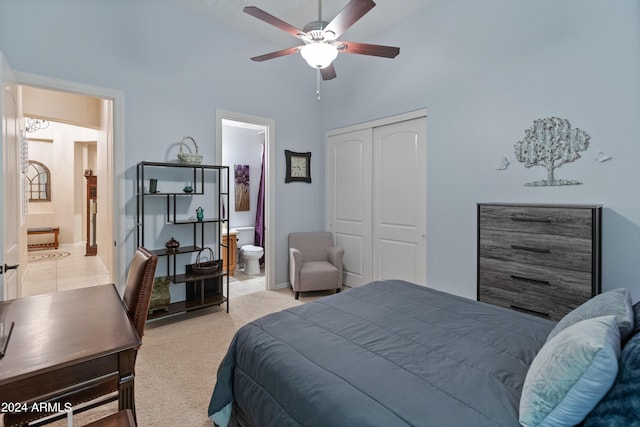 bedroom featuring high vaulted ceiling, light colored carpet, ceiling fan, ensuite bath, and a closet