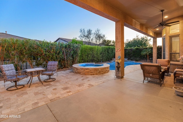 view of patio featuring ceiling fan and a pool with hot tub