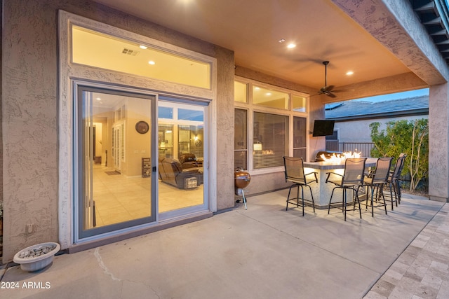 view of patio / terrace with a bar, ceiling fan, and a fire pit