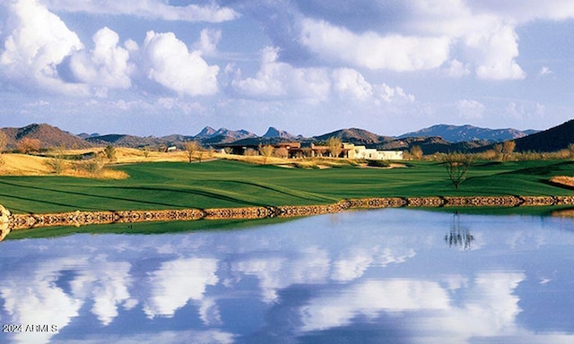 exterior space with a water and mountain view and a yard