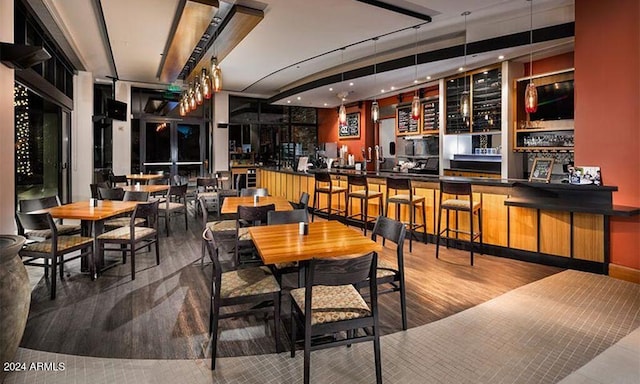 dining area with bar and hardwood / wood-style flooring