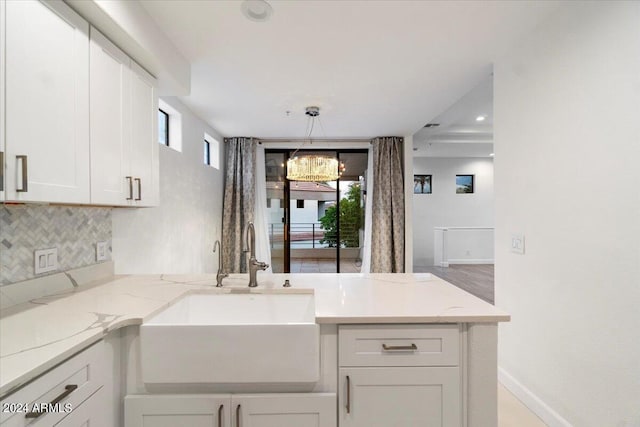 7222 E Gainey Ranch Rd Unit 241, Scottsdale, AZ 85258 - kitchen featuring a sink, white cabinets, tasteful backsplash, light stone countertops, and recessed lighting