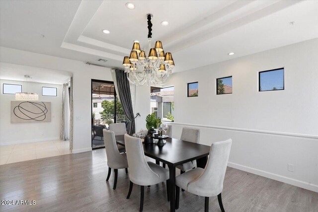 7222 E Gainey Ranch Rd Unit 241, Scottsdale, AZ 85258 - dining space with a chandelier, wood finished floors, baseboards, recessed lighting, and a tray ceiling