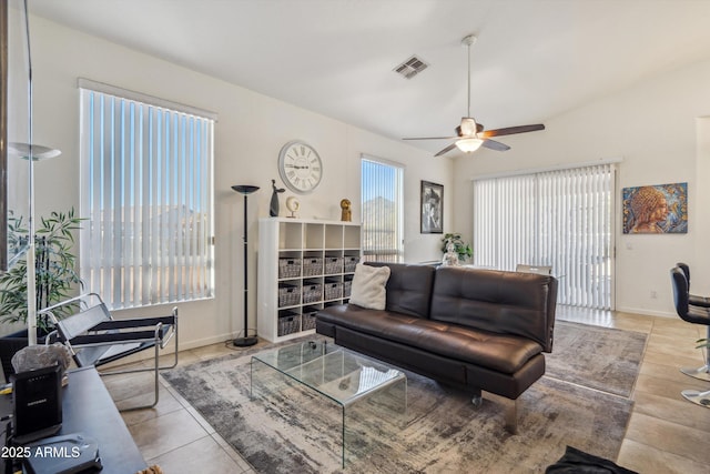 living room with ceiling fan, light tile patterned floors, and vaulted ceiling