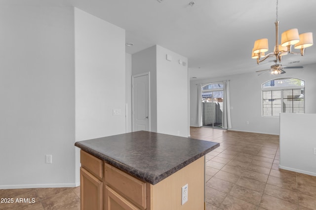 kitchen featuring dark countertops, ceiling fan, a chandelier, and baseboards
