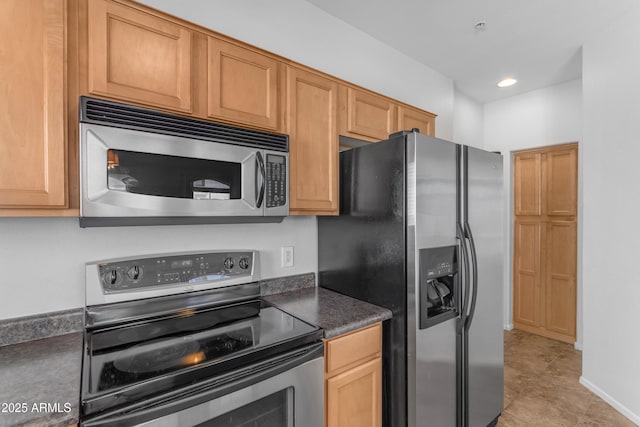 kitchen featuring stainless steel appliances, dark countertops, recessed lighting, and light tile patterned floors