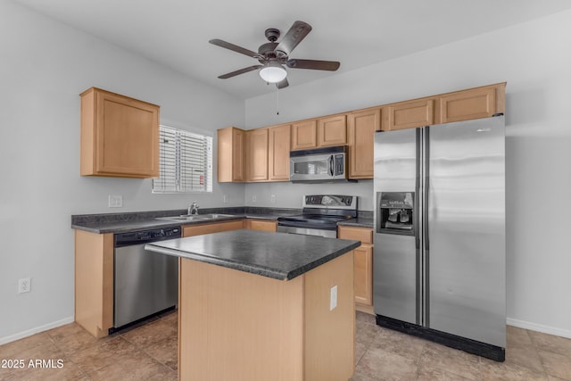 kitchen featuring appliances with stainless steel finishes, a sink, ceiling fan, dark countertops, and a center island
