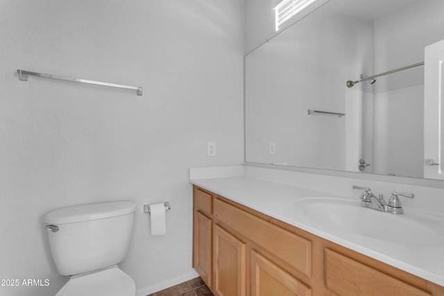 bathroom featuring vanity, toilet, tile patterned flooring, and baseboards