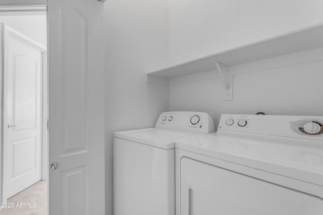 washroom featuring separate washer and dryer and light carpet