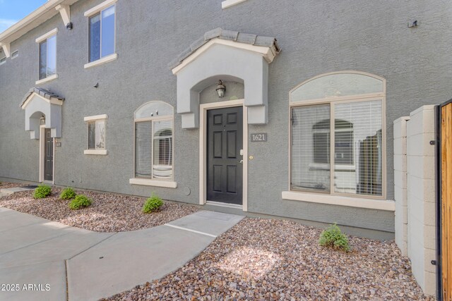 view of exterior entry featuring stucco siding