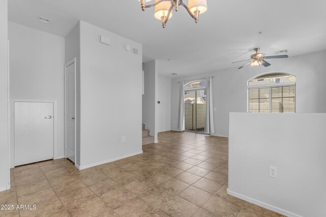 empty room with healthy amount of natural light, stairway, a chandelier, and baseboards