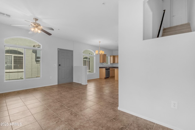 unfurnished living room with a chandelier, ceiling fan, tile patterned floors, and baseboards