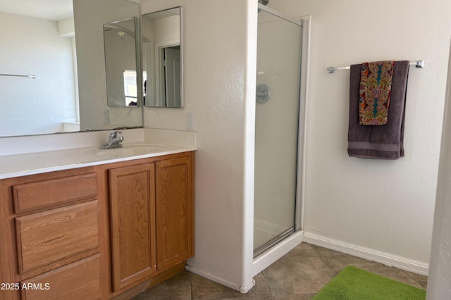 bathroom featuring tile patterned floors, a shower stall, baseboards, and vanity