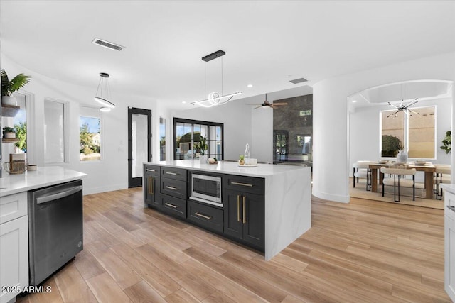 kitchen featuring white cabinetry, stainless steel appliances, dark cabinets, and decorative light fixtures