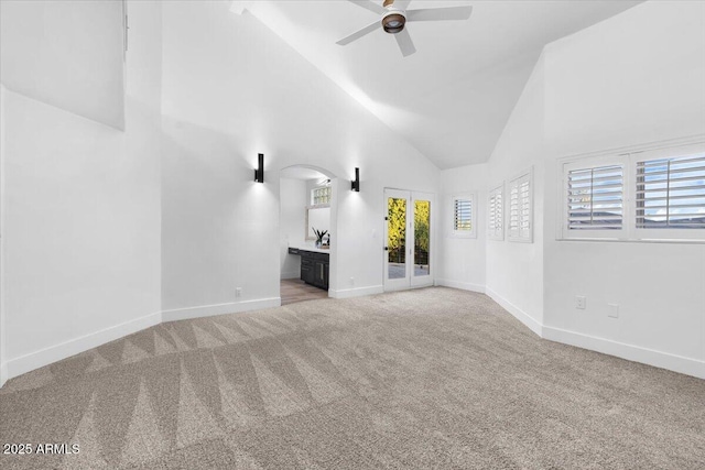 spare room with carpet, high vaulted ceiling, ceiling fan, and baseboards