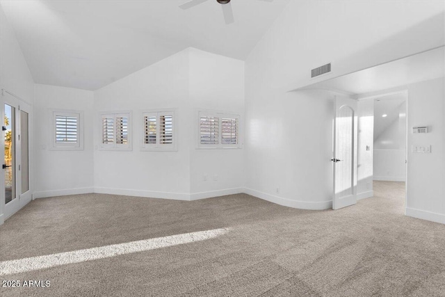 spare room featuring baseboards, visible vents, light colored carpet, lofted ceiling, and ceiling fan