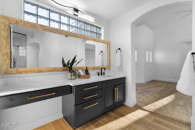 bathroom featuring visible vents, wood finished floors, vanity, and baseboards