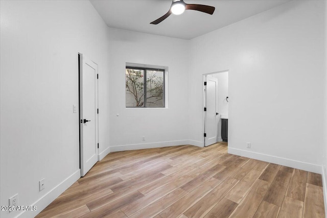 empty room featuring light wood-style floors, ceiling fan, and baseboards