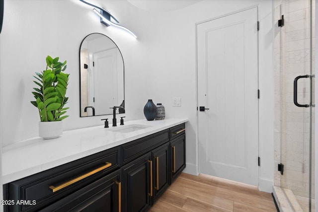 full bath featuring a stall shower, wood finished floors, and vanity