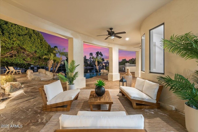 patio terrace at dusk with an outdoor hangout area and a ceiling fan