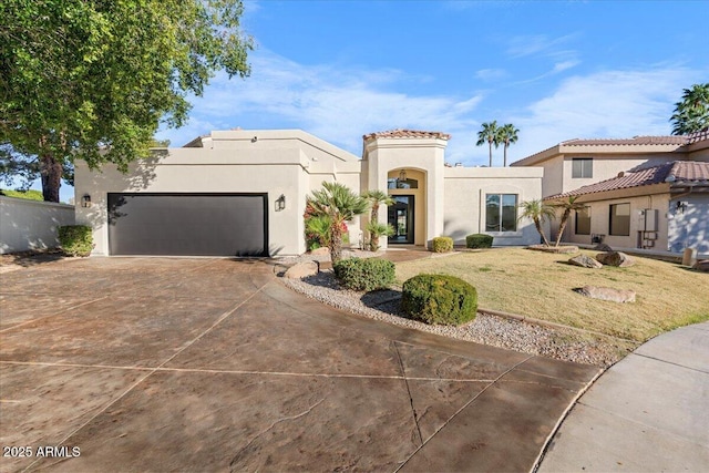 mediterranean / spanish house with a garage, concrete driveway, a front lawn, and stucco siding