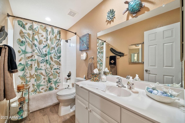 full bathroom featuring vanity, hardwood / wood-style floors, toilet, and shower / bath combo with shower curtain