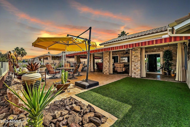 yard at dusk featuring a patio