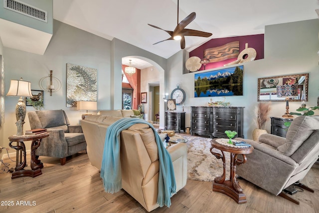 living room with vaulted ceiling, ceiling fan, and light wood-type flooring