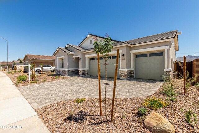 12029 W Marguerite Ave, Avondale, AZ 85323 - view of front of property with a garage, stone siding, decorative driveway, stucco siding, and a tile roof