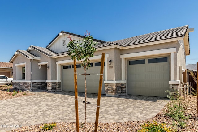 12029 W Marguerite Ave, Avondale, AZ 85323 - view of front facade featuring stone siding, an attached garage, decorative driveway, and a tile roof