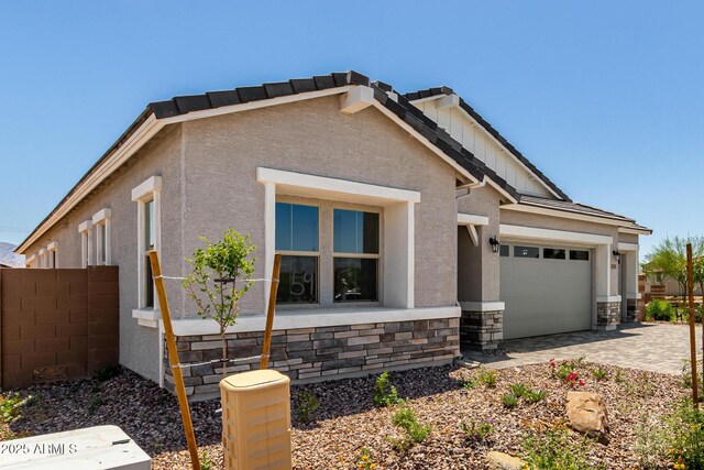 12029 W Marguerite Ave, Avondale, AZ 85323 - view of front of house with stone siding, an attached garage, board and batten siding, stucco siding, and driveway