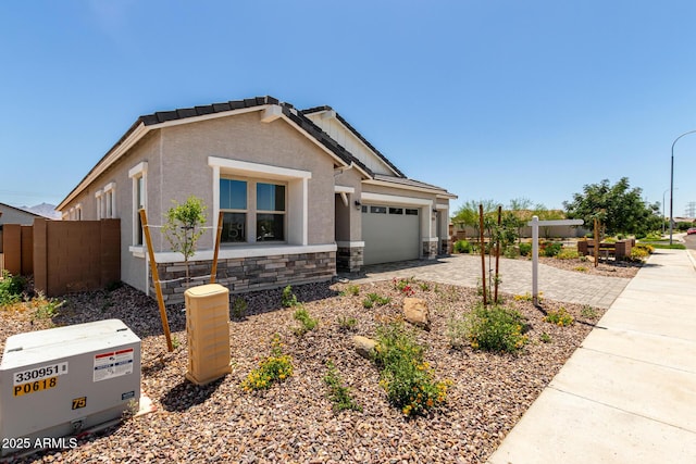 12029 W Marguerite Ave, Avondale, AZ 85323 - view of front of property with stone siding, an attached garage, driveway, and stucco siding