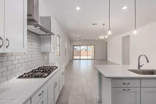 12029 W Marguerite Ave, Avondale, AZ 85323 - kitchen with a sink, wall chimney range hood, stainless steel gas stovetop, light countertops, and decorative backsplash