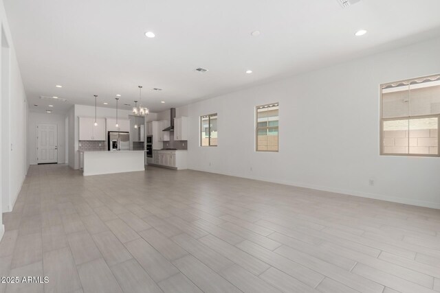 12029 W Marguerite Ave, Avondale, AZ 85323 - unfurnished living room featuring a chandelier, recessed lighting, light wood-style floors, and baseboards