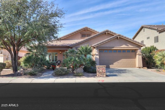 view of front of house featuring concrete driveway, an attached garage, a tiled roof, and stucco siding