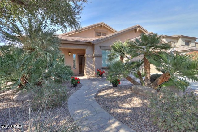 view of front of property featuring a tiled roof and stucco siding