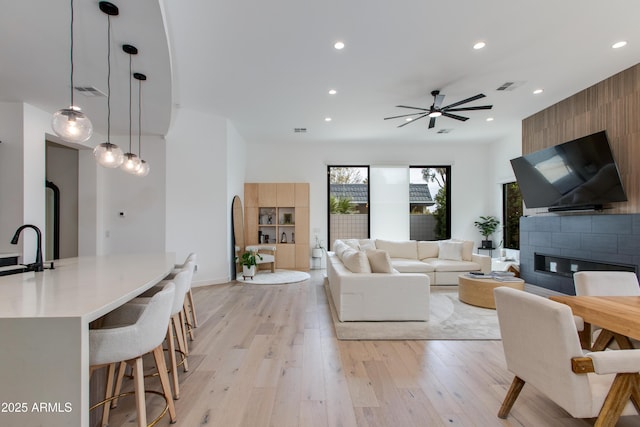 living room with recessed lighting, a ceiling fan, visible vents, and light wood-style floors