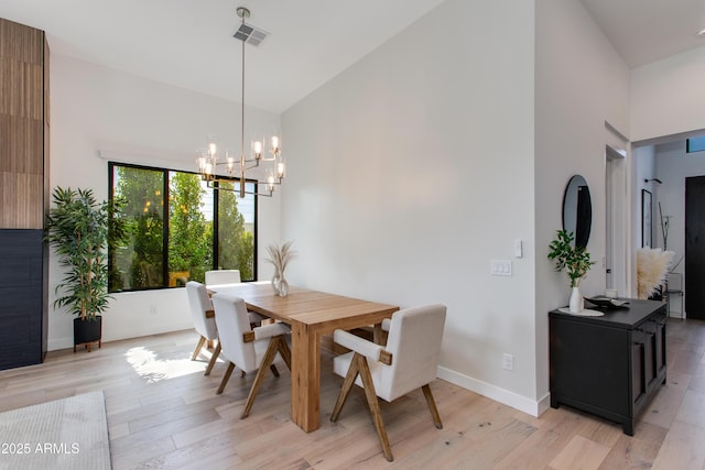 dining area featuring an inviting chandelier, visible vents, baseboards, high vaulted ceiling, and light wood finished floors